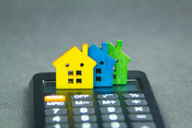 The house is placed on a calculator. Plan coin savings to buy concept houses for real estate, mortgages 