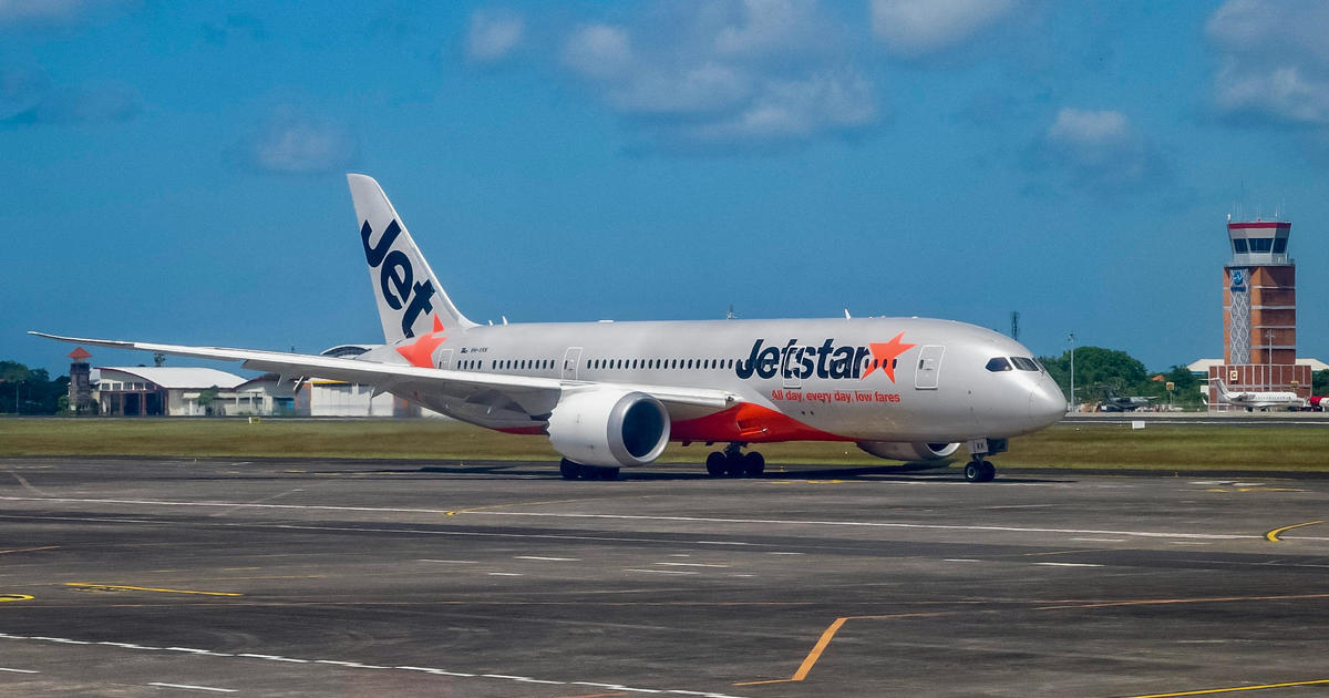 Passenger opens jet door and steps onto the wing after landing at Australian airport