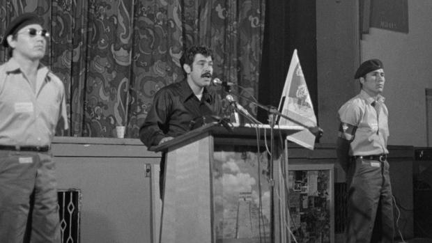 Rodolfo Gonzales Speaking at Podium 