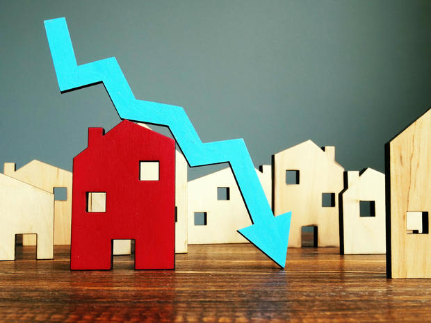 The crisis in the real estate market. Falling home value. Property and downward arrow. 