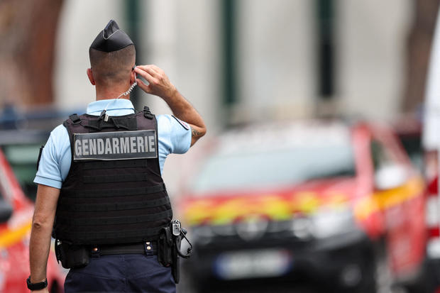 French police stand guard after cars were set on fire in front of the city's synagogue, in La Grande-Motte 