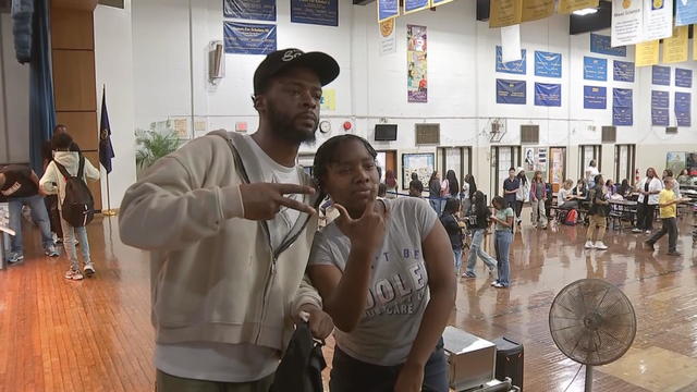 KUR poses for a photo with a student at Saul High School 