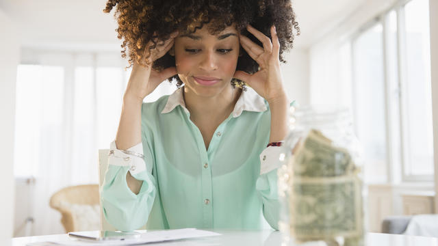 Stressed mixed race woman paying bills 