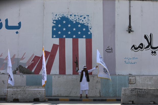 A member of the Afghan Taliban celebrates the third anniversary of the group's takeover of Afghanistan in front of the former U.S. Embassy compound in Kabul