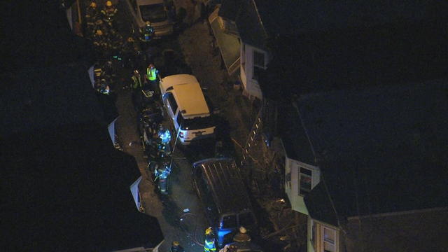 Firefighters are seen on the scene of a rowhome fire in West Philadelphia 