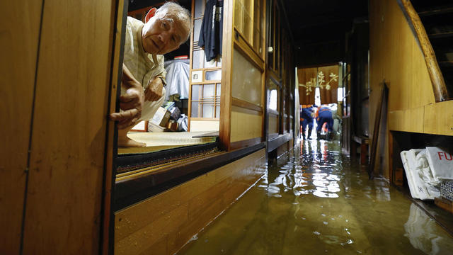 A man looks on inside his flooded house at an area affected by floods due to heavy rains caused by Typhoon Shanshan in Ogaki 