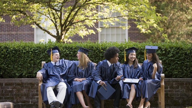 Graduates relax and talk after graduation. 