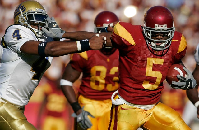 USC's Reggie Bush grabs the facemask of UCLA Bruin Jarrad Page in USC's 6619 win at the LA Coliseu