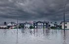 Extreme heavy rain storm weather. Flooded streets of the neighborhood. A flooded road junction with a drowned house. Heavy rains from tropical storm caused many flooded areas. Rains caused many floods 