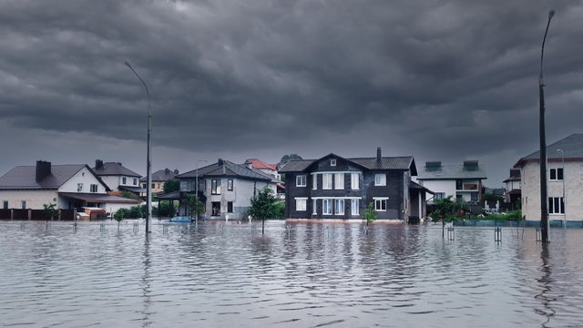 Extreme heavy rain storm weather. Flooded streets of the neighborhood. A flooded road junction with a drowned house. Heavy rains from tropical storm caused many flooded areas. Rains caused many floods