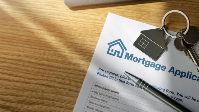 mortgage loan application form and new home keys on the bank office table. copy space 
