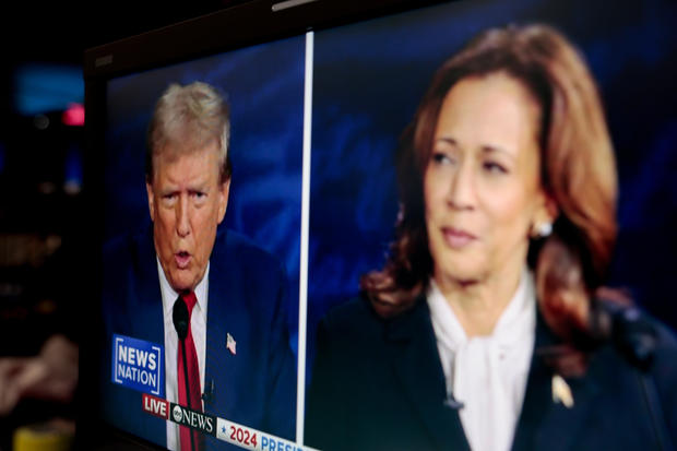 Former President Donald Trump and Vice President Kamala Harris are shown on screen in the spin room during the second presidential debate 