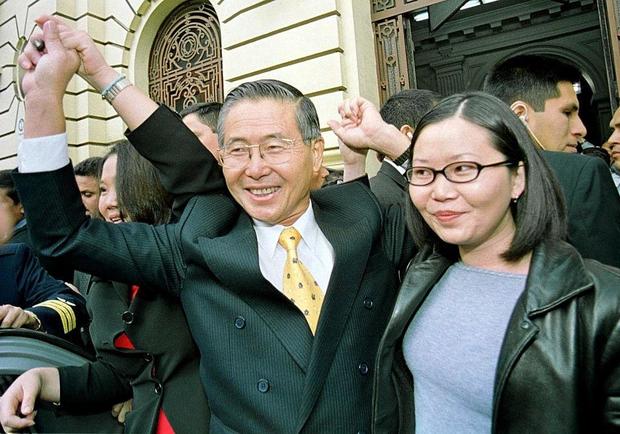 Peruvian President Alberto Fujimori (C), accompanied by his daughters, Peruvian First Lady Keiko Fujimori (L), and Sachi Marcela Fujimori (R), greeting supporters as he leaves a polling station after casting his vote in Lima in a runoff election on May