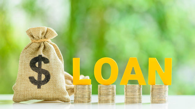 Consumer and personal loan, financial concept : Loan bags, row of coins with the word LOAN on a table, depicting financial flexibility for life's expenses, unlock borrower's goal with personal loan. 