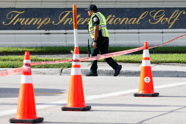A law enforcement officer walks in front of a sign for former President Donald Trump's Trump International Golf Course in West Palm Beach, Florida, after shots were fired Sept. 15, 2024.