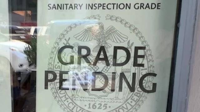 A sanitary inspection grade sign in a New York City restaurant window reading "grade pending." 