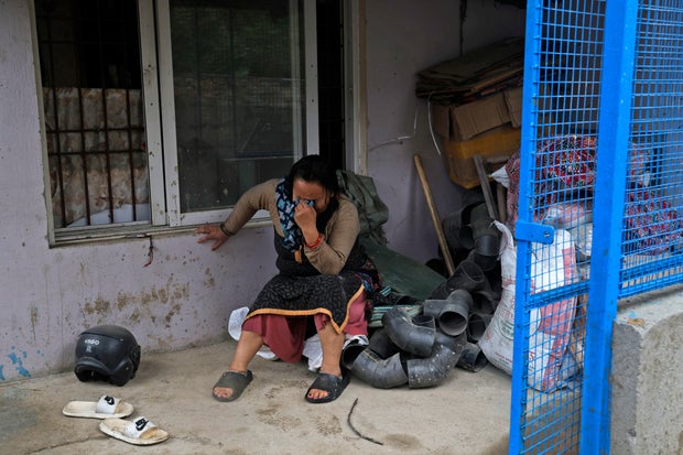 A woman cries after she lost her home due to floods caused by heavy rains in Kathmandu, Nepal