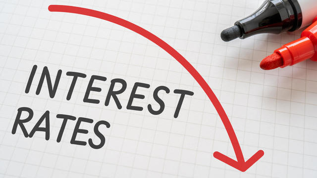 White paper written "INTEREST RATES" with markers. 