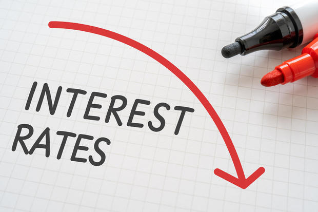 White paper written "INTEREST RATES" with markers. 