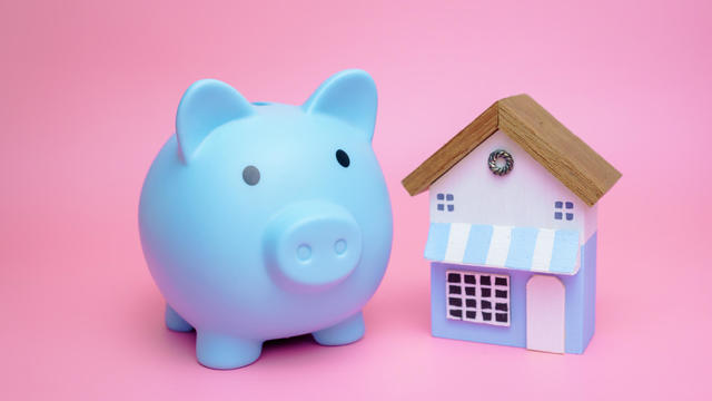 piggy bank and miniature house, concept of saving money to buy a house. 