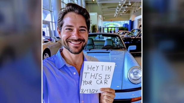 A picture of a man standing in front of what appears to be a blue porsche and holding a piece of paper that says "Hey Tim this is your car 8/13/24." 