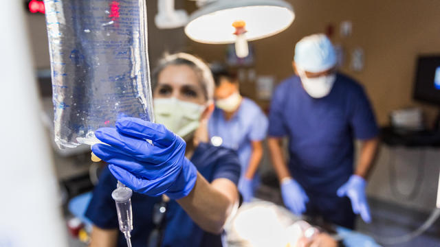 Doctor checks IV bag 