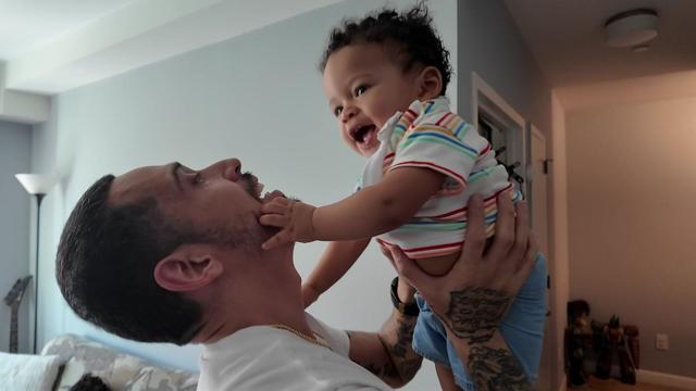 Jose Perez holds his 10-month-old son over his head. 