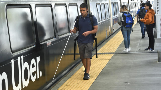 A blind man catches a train in Denver, Colorado 