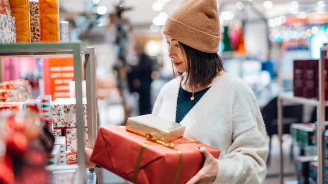 Young woman shopping Christmas gifts in department store 