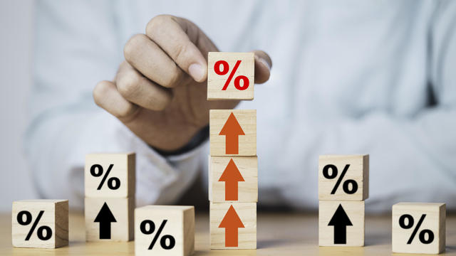 Businessman putting percentage sign which print screen on wooden cube block to up arrow for business profit and economic growth concept. 