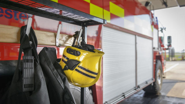 Firemans helmet hanging by fire engine in fire station 