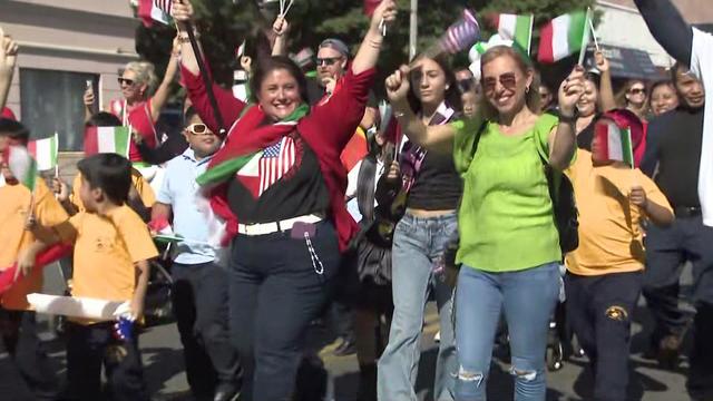 Participants march in Brooklyn's Columbus Day Parade and wave Italian flags. 