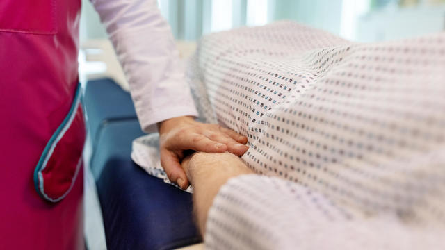 Close-up of radiologist consoling man in MRI scan room 