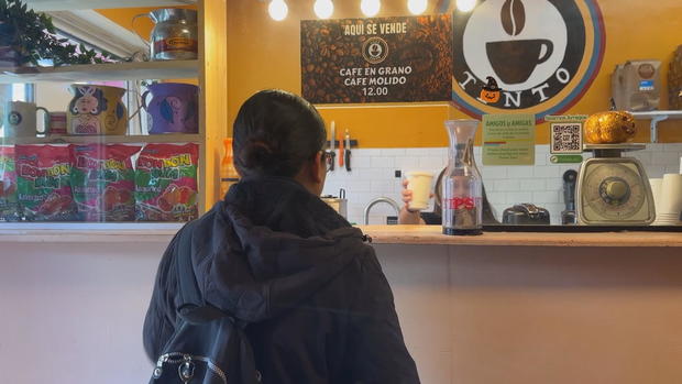 A customer gets coffee at the counter at Cafe Tinto 