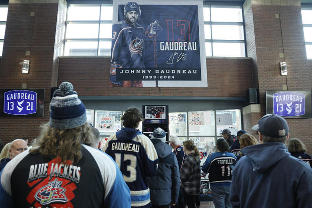 Fans look at a memorial of Columbus Blue Jackets' Johnny Gaudreau and his brother Matthew at the arena 