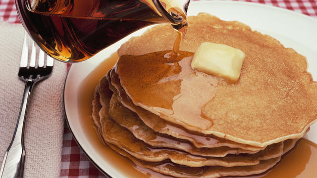 Pouring Maple Syrup on Plate of Pancakes 