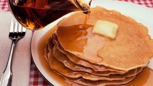Pouring Maple Syrup on Plate of Pancakes