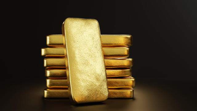 Gold bullion leaning on a stack of gold ingots. Illustration of the concept of precious metal trade and wealth 