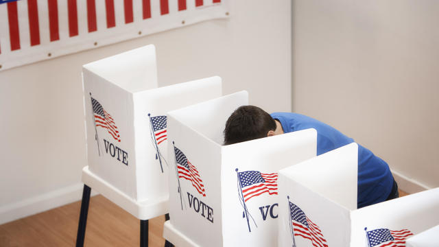 Caucasian voter voting in polling place 