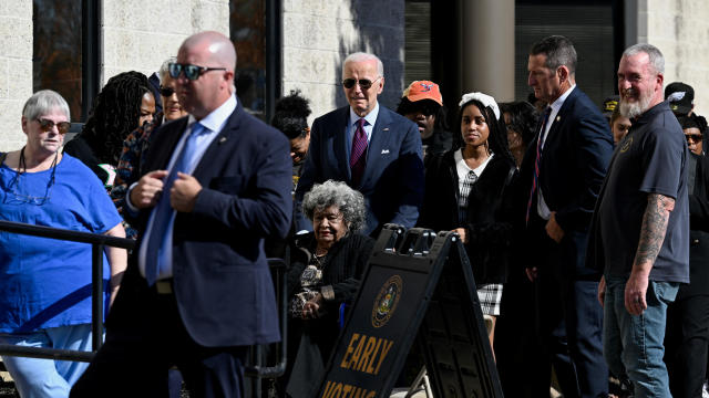 President Biden helps a woman in a wheelchair as he arrives to vote in the 2024 presidential election, in New Castle, Delaware, Oct. 28, 2024. 