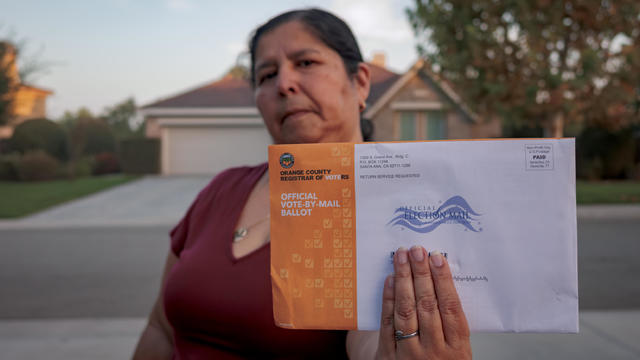 A woman seen holding an Official Vote-By-Mail Ballot. Early 