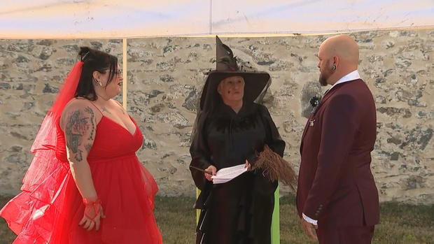 A couple dressed as Beetlejuice and Lydia are married by a clerk dressed as a witch 