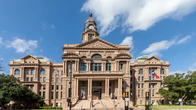 Tarrant County Courthouse in Fort Worth with the Texas flag fluttering in the wind. 