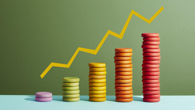 Five stacks of coloured coins with a graph line above 