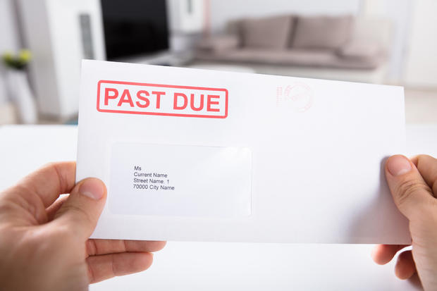 Person Holding Past Due Bill Envelope 