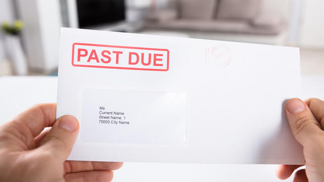 Person Holding Past Due Bill Envelope 