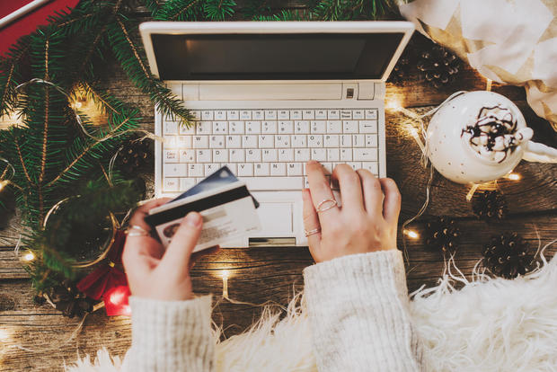 Woman using credit card to shop online, close up 