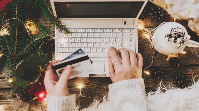 Woman using credit card to shop online, close up 