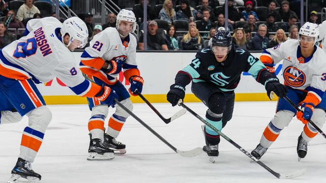 Noah Dobson #8 of the New York Islanders moves the puck as Jamie Oleksiak #24 of the Seattle Kraken reaches to intercept during the third period of a game at Climate Pledge Arena on November 16, 2024 in Seattle, Washington. 