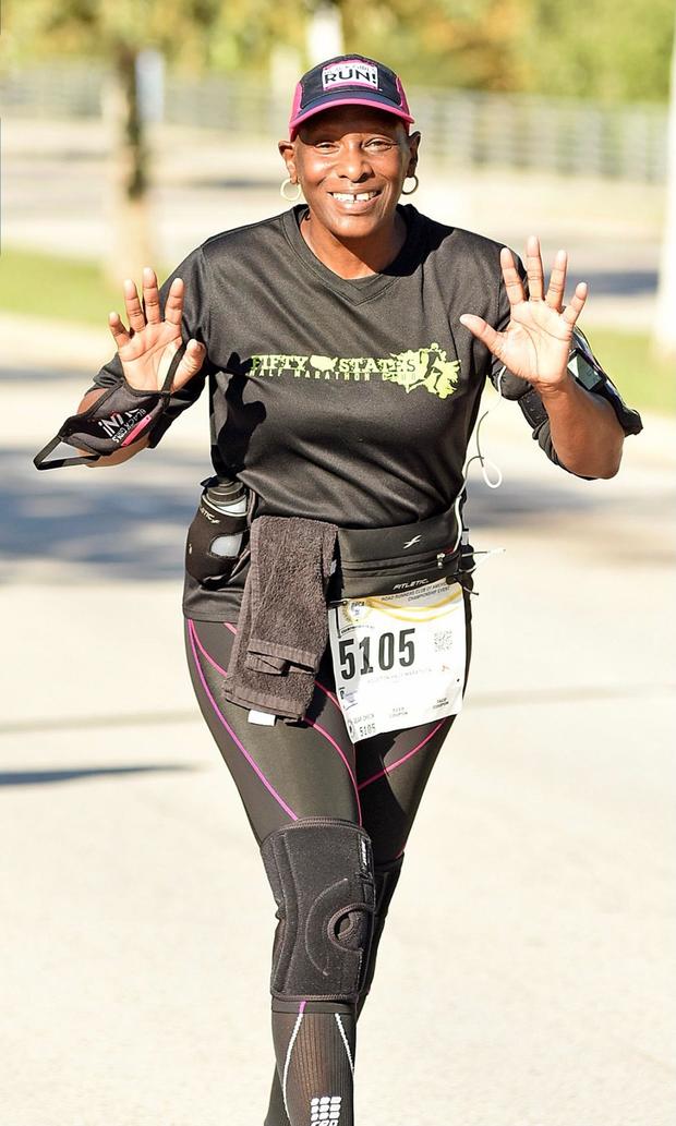 Denise Hall waves and smiles during a race 